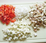 Чеснок очистите и измельчите. Баклажан и цукини очистите от кожуры и нарежьте на кубики. Лук очистите и измельчите, перец очистите от плодоножки и семян и нарежьте на крупные кусочки.	