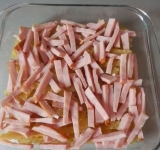 Посыпьте слой ветчины солью и специями по вкусу (не переборщите с солью, ветчина соленая). 
Соедините молоко с водой, можно немного посолить смесь. Можно также использовать только молоко, главное не нарушить соотношение макароны-жидкость, ведь они должны свариться.	