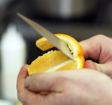 Начинаем готовить украшение, для этого очищаем апельсин и нарезаем его дольками.	