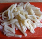 Нарезаем кальмары кольцами.	