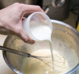 Предварительно доведите до кипения смесь молока со сливками и слегка остудите. Добавьте молочную смесь к взбитым желткам. Перемешайте.	