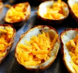 Когда кожура подрумянилась, выкладываем в нее сыр.