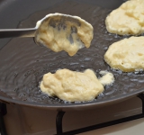 На разогретую сковороду наливаем растительное масло, рядом ставим стакан с водой. Окуная столовую ложку в воде, выкладываем тесто на сковороду.	