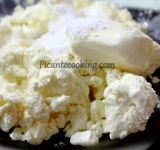 На сухой сковороде обжариваем фундук и даем полностью остыть. Творог посыпаем сахарной пудрой, добавляем сметану и тщательно перемешиваем. 
У фиников удаляем косточки и измельчаем блендером. 8 орешков откладываем в сторону, они нам понадобятся в дальнейшем для украшения. Остальные измельчаем в блендере.	