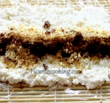 Творог раскладываем по периметру пленки. В центр вдоль выкладываем финики, фундук, посыпаем корицей.	