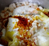 Добавляем приготовленные цукаты с марципанами и шафран с ромом к подросшему тесту.	