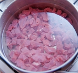 Мясо положите в кастрюлю, залейте водой и поставьте на плиту. Доведите до кипения и варите на слабом огне около 2 часов. Снимайте образующуюся пенку с поверхности.	
