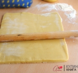 Для начала холодное масло нарежьте на небольшие кусочки и взбейте при помощи миксера или комбайна. Добавьте соль, сахар и ванильный сахар. Одно яйцо и один желток немного взбейте в отдельной миске и вливайте понемногу. 
 
Соду (на кончике ножа) погасите уксусом и введите в тесто. Просейте в тесто муку и хорошенько замесите тесто. Поставьте в холодильник минут на 30. 
 
Охлажденное тесто разделите на 2 части. Если у вас большой противень, то тесто можно не делить на 2 части, а просто испечь 1 большой корж и потом разрезать.	